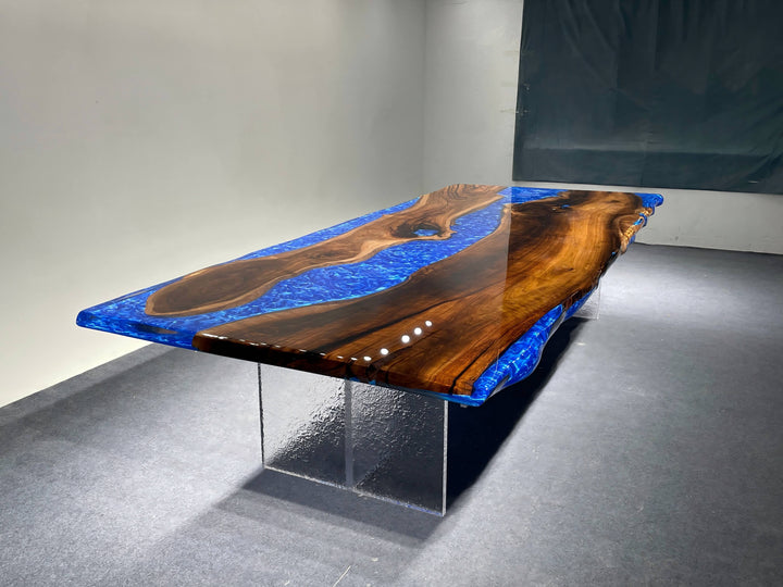 Modern dining table with blue resin and wood design on a gray floor.