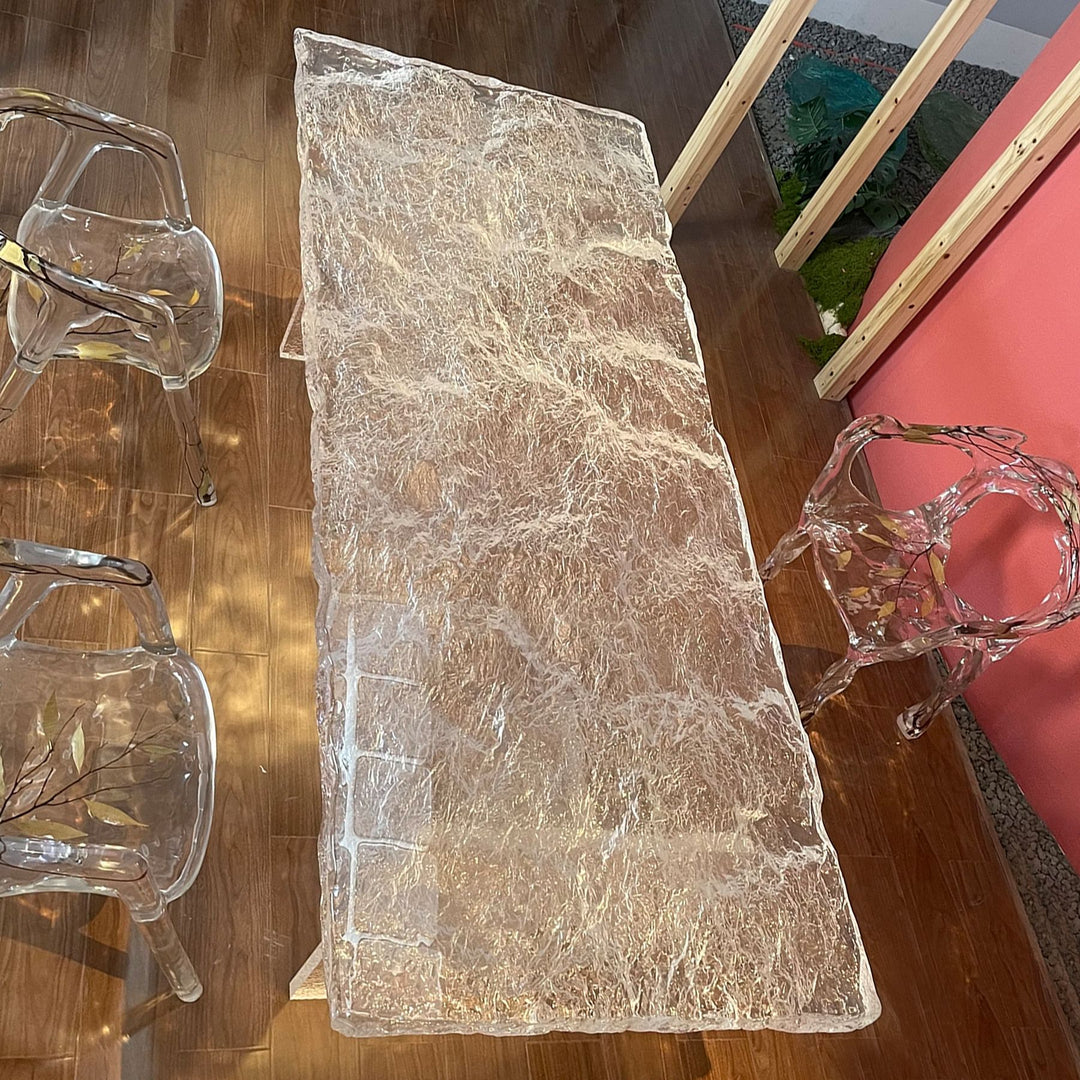 A stunning resin dining table with a textured surface and clear, modern - styled legs.