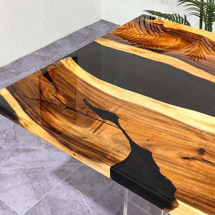 Black resin river table crafted from solid walnut wood with a natural edge
