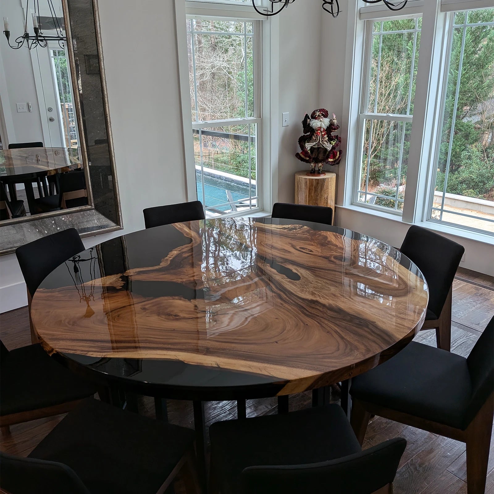 Round walnut resin table with black epoxy and natural grain in modern dining room