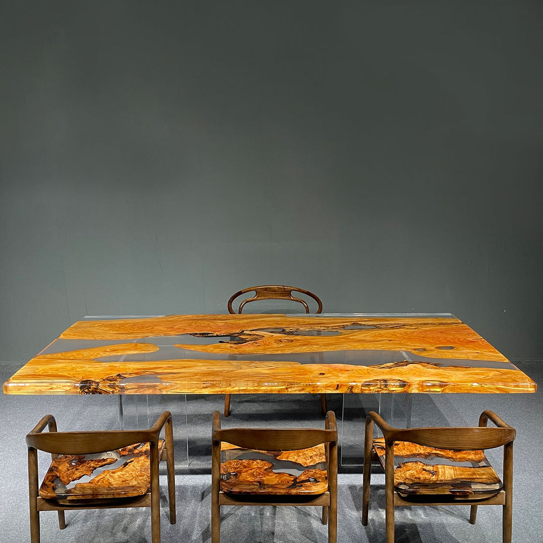 Olive wood resin table with a transparent base and a matching wooden chair in the background