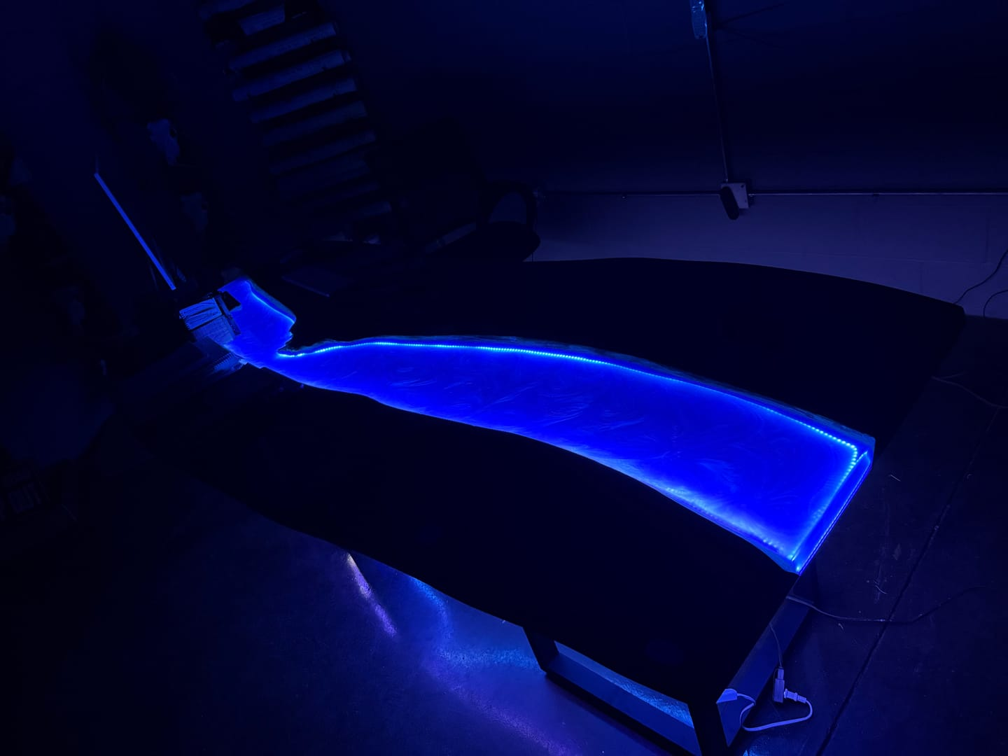 Handcrafted black walnut and Swirling Ocean Blue epoxy dining table with LED illumination and full gloss finish, adding elegance to modern interiors.