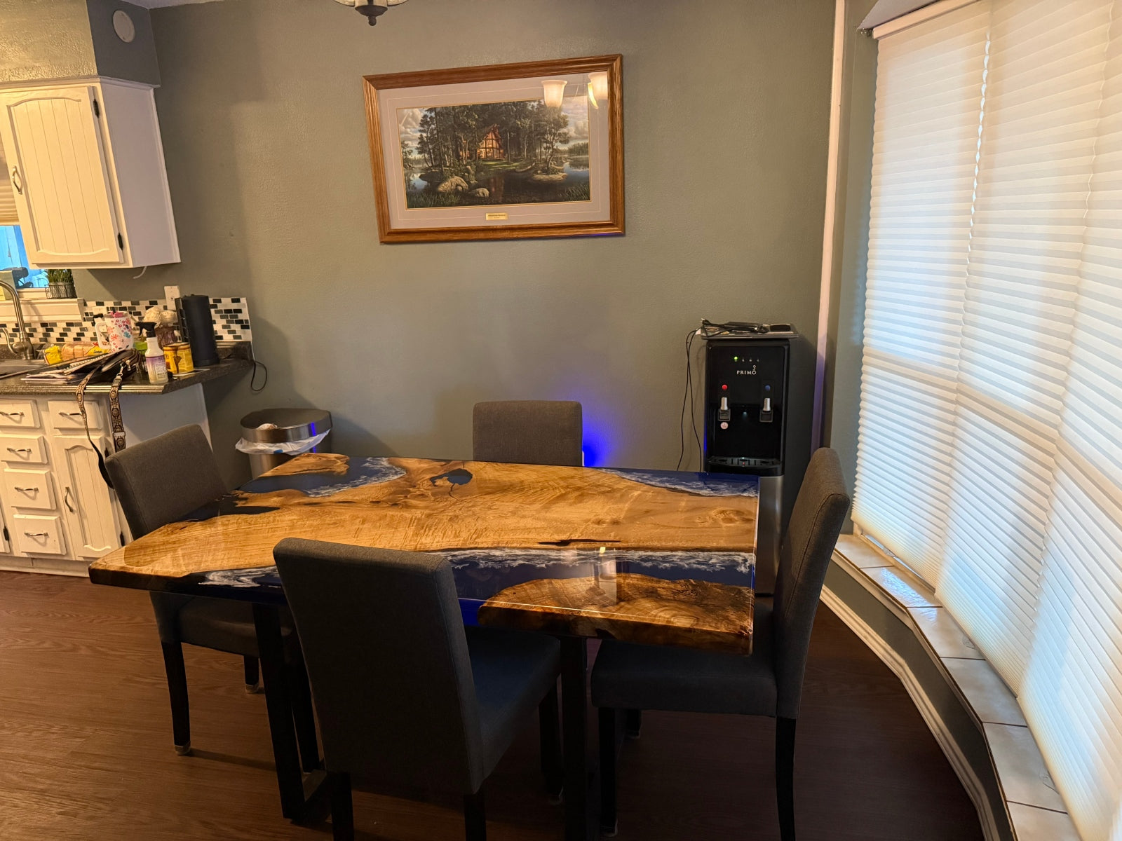 Handcrafted golden camphor and clear blue epoxy ocean wave dining table displayed in a modern home interior, showcasing natural elegance and ocean inspiration.