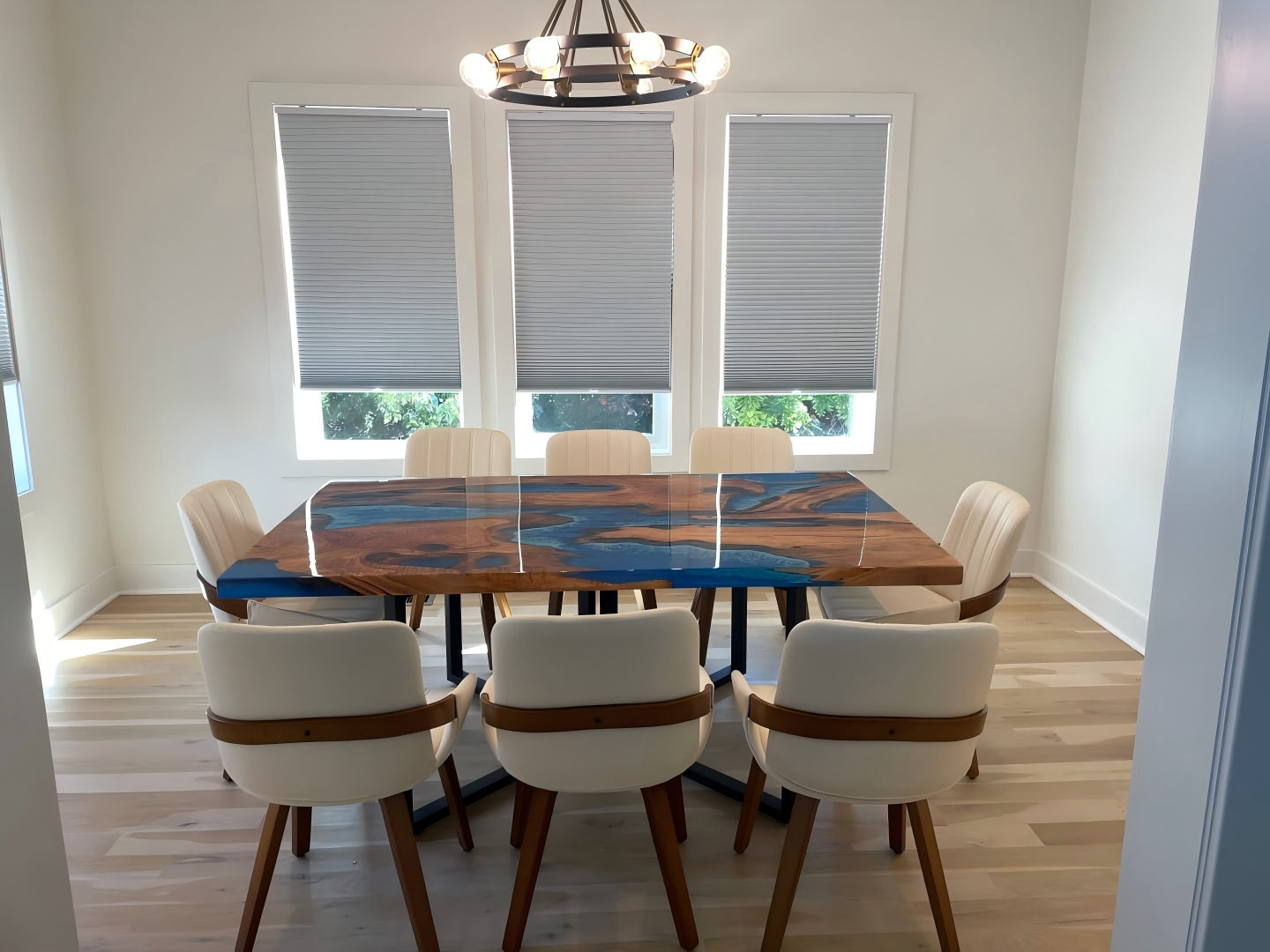 Close-up of olive wood epoxy table with swirling ocean blue resin and rich wood grain