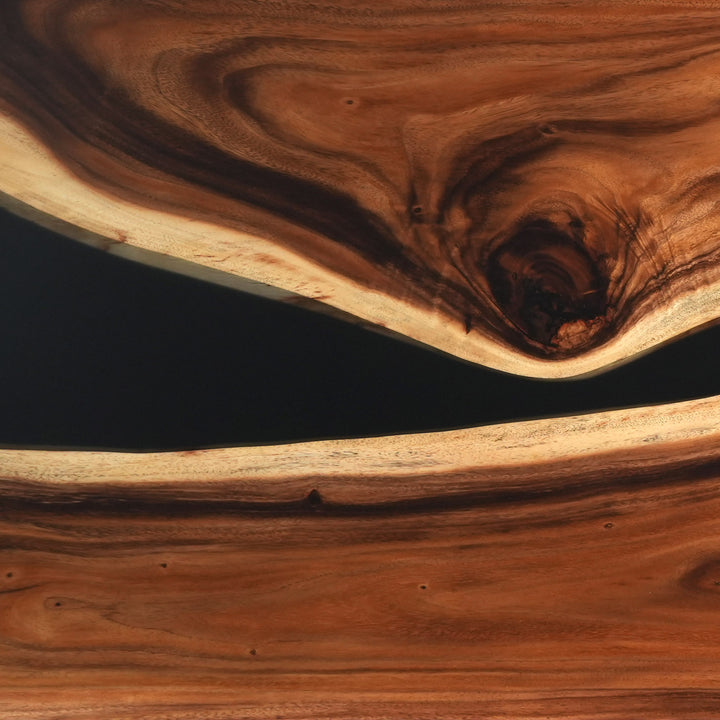 Surface detail of a custom epoxy table capturing the striking contrast between the warm walnut wood and the deep black glossy resin river - SeawaveTable