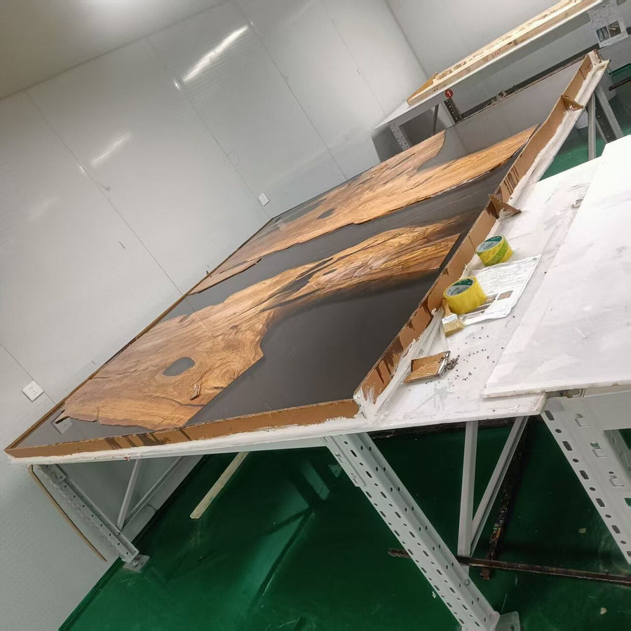Wooden panel with black surface on a white platform in a workshop setting