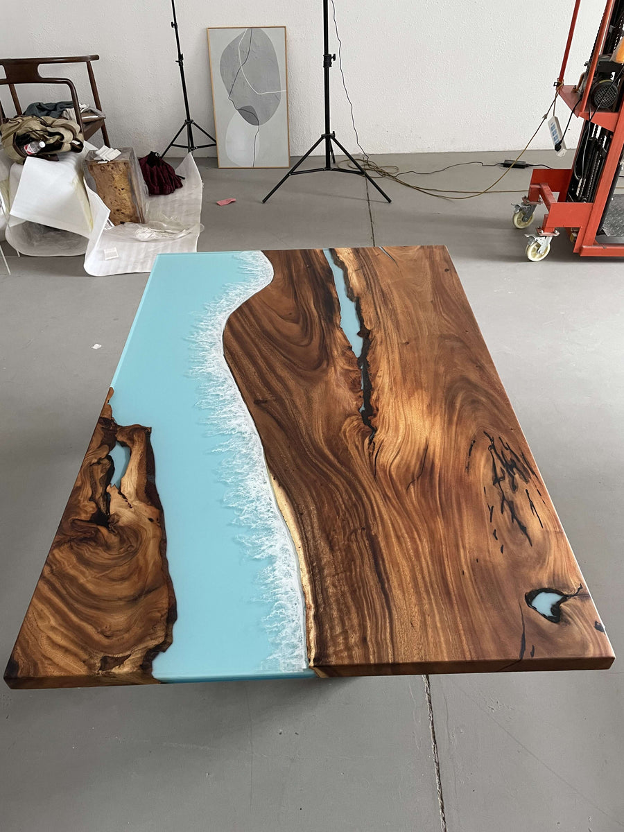 Wooden table with blue resin inlay in a studio setting
