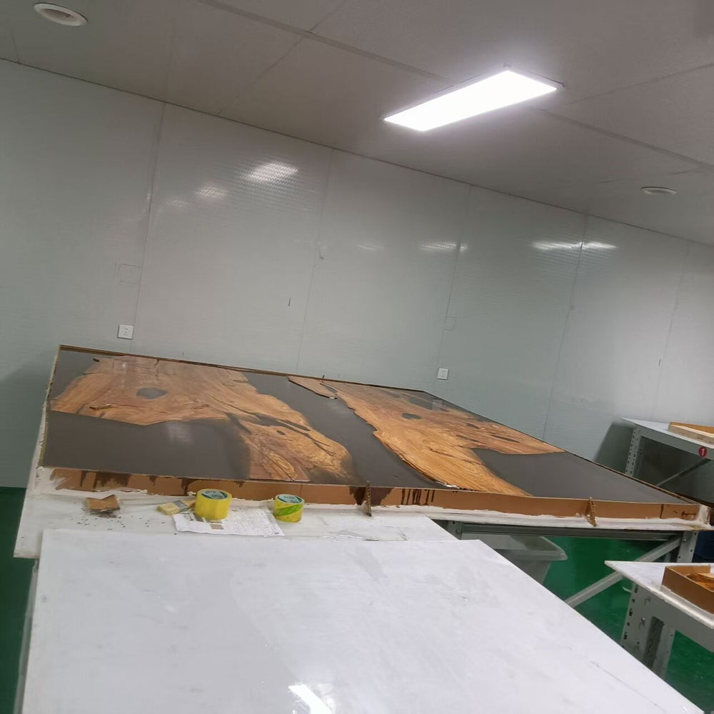 Workshop or factory interior with a large wooden panel on a table