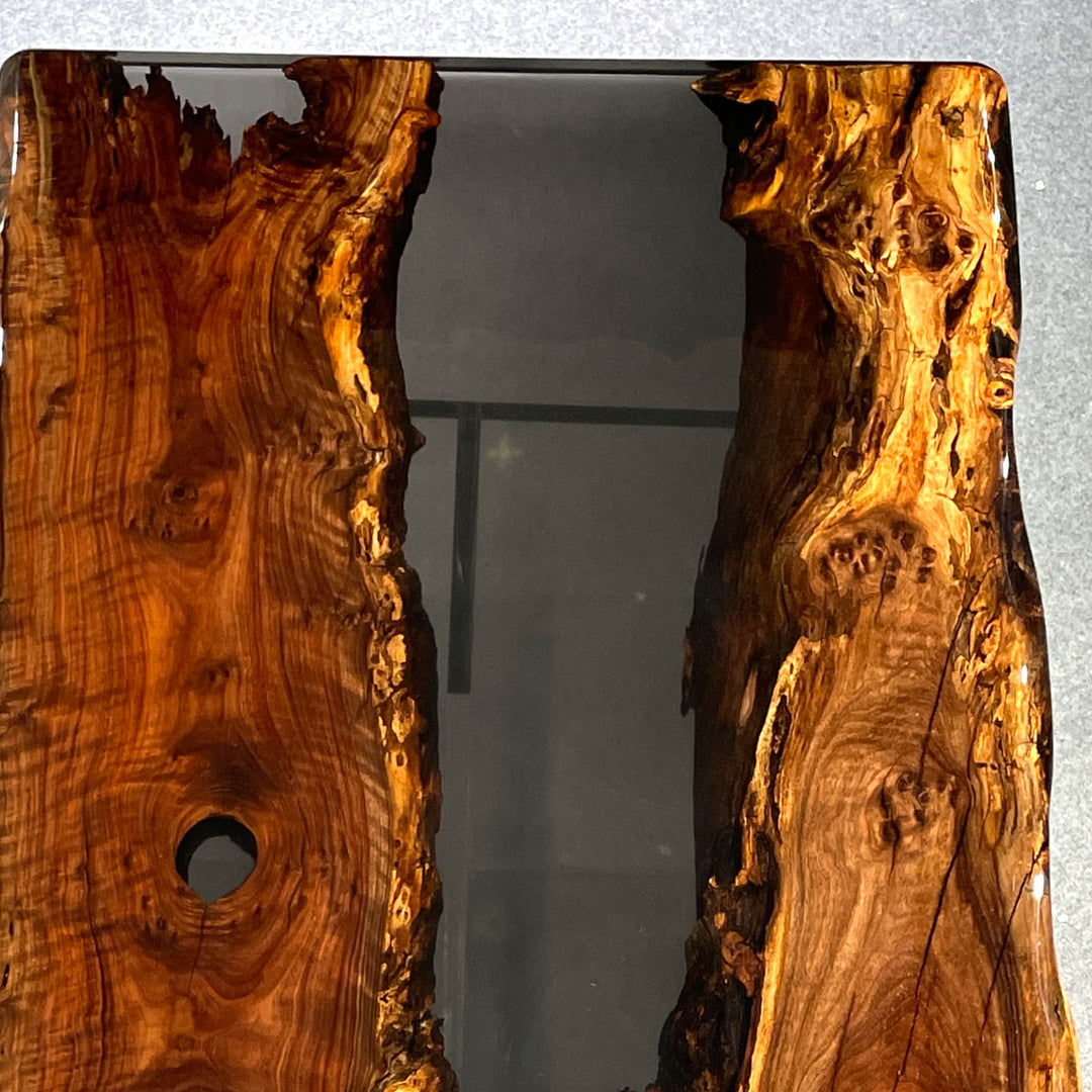 Detail shot of Walnut live edge meeting semi-transparent black resin