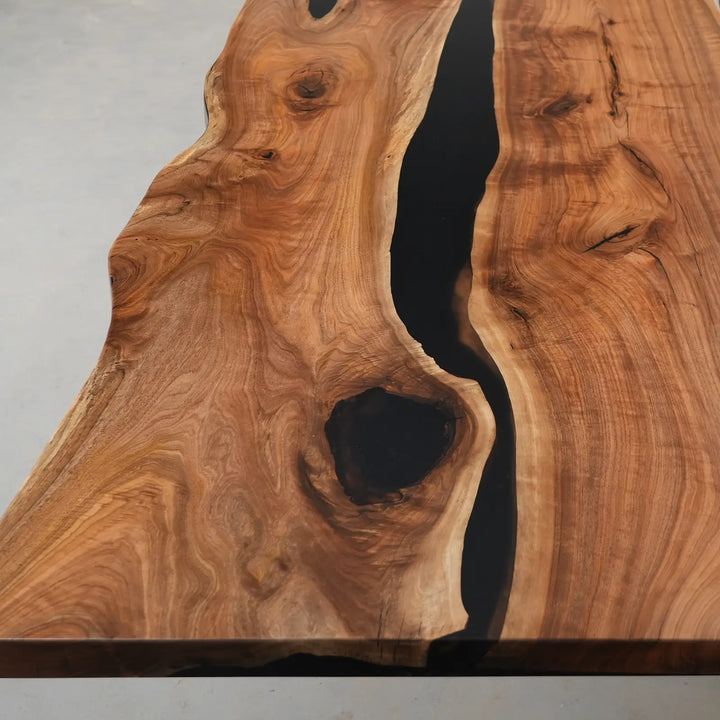 Contemporary black walnut river table combining organic hardwood textures with modern resin craftsmanship.