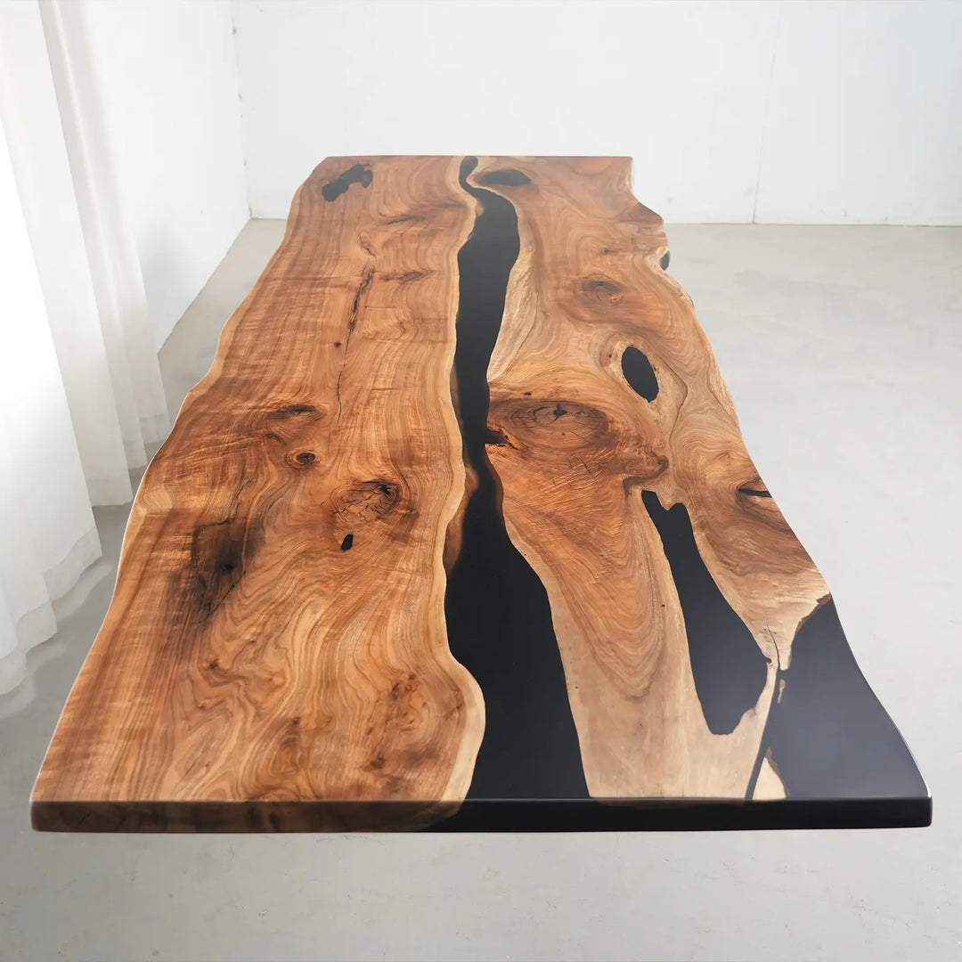Modern organic dining table with rich walnut wood tones and a bold black epoxy river centerpiece.