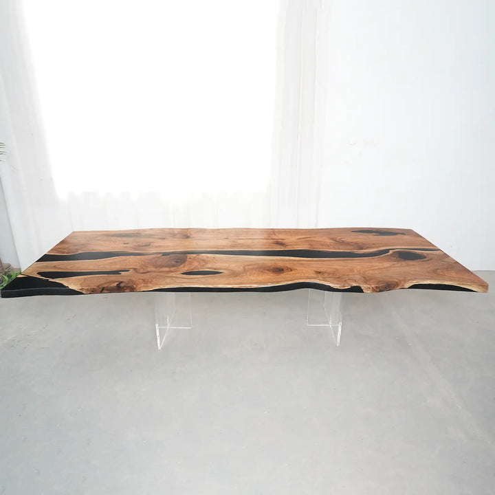 Black epoxy river flowing between two natural black walnut slabs in a handcrafted dining table.
