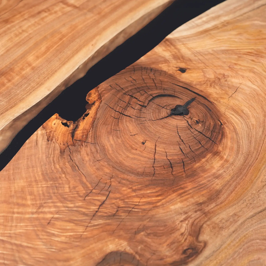 Close-up of natural black walnut wood grain and black translucent epoxy resin river detailing.