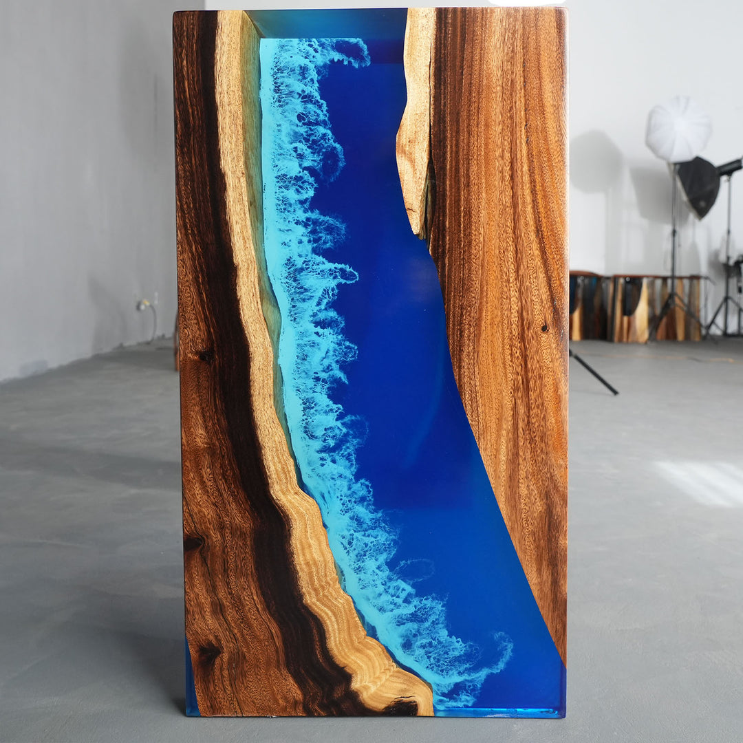 Close-up of live edge walnut wood grain with deep blue epoxy resin river.