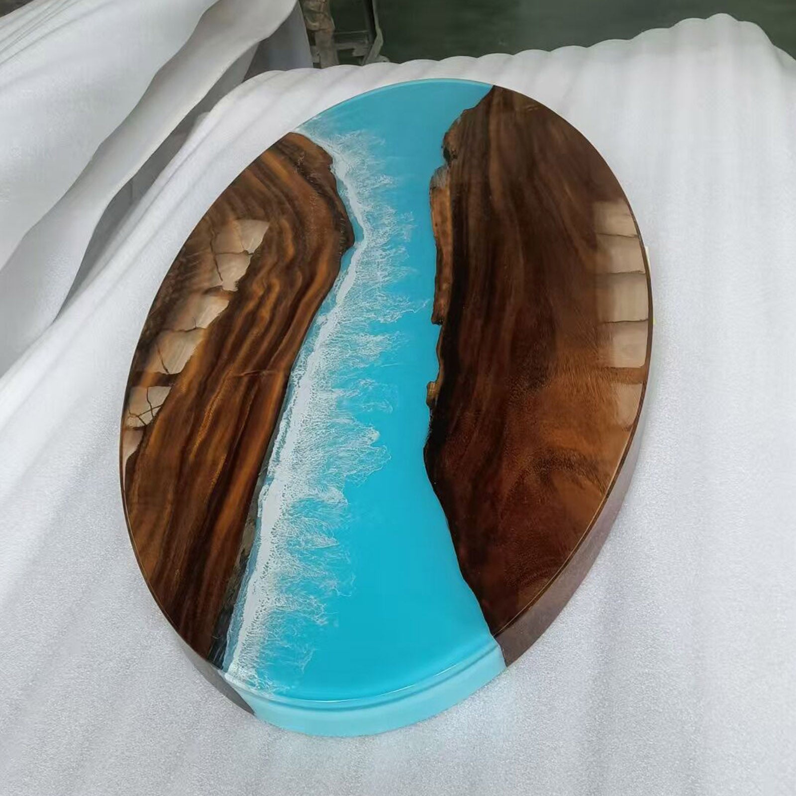 Handcrafted oval walnut coffee table with Ocean Serenity resin in a modern living room setting.