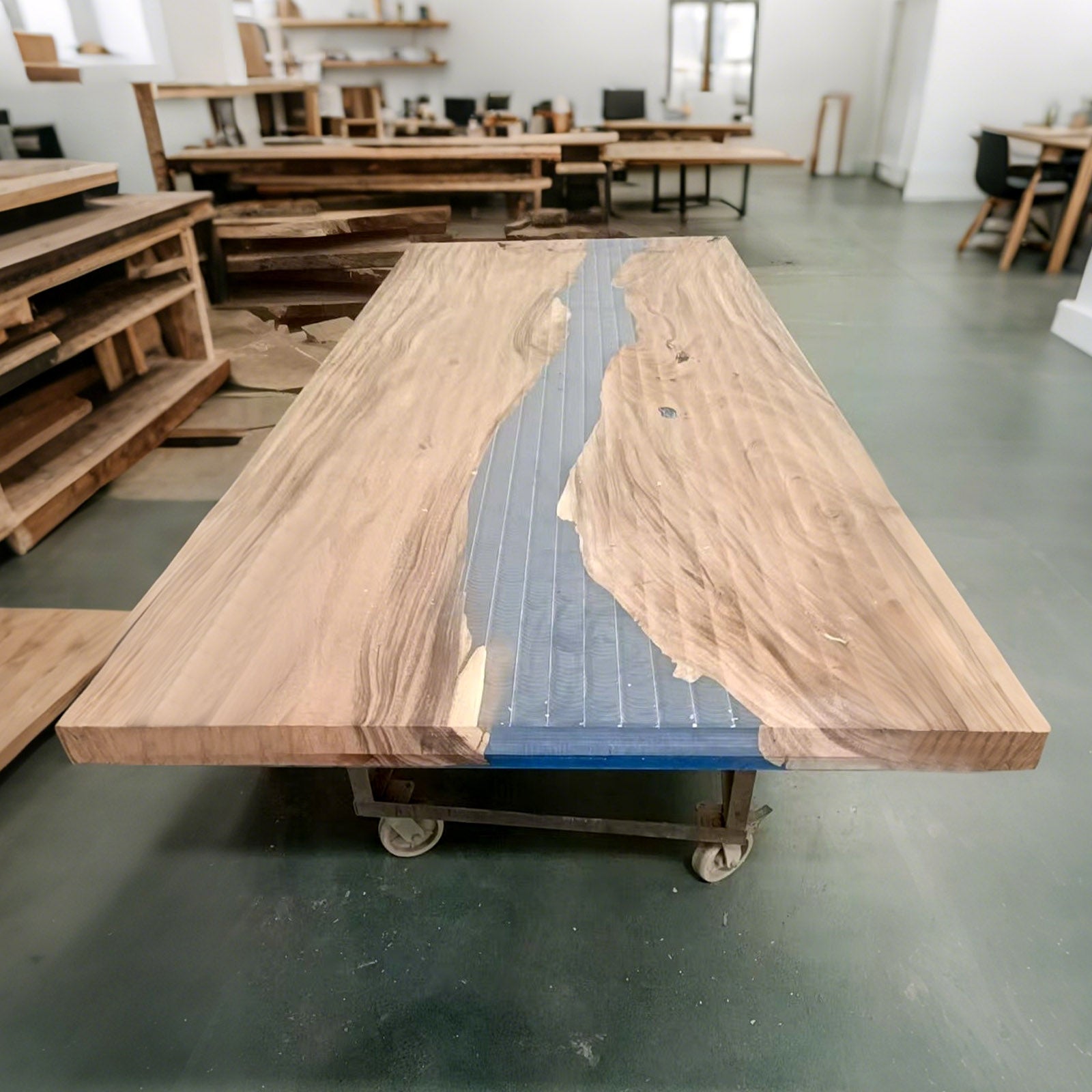 Close-up of swirling ocean blue resin and walnut wood grain on handcrafted banquet table, showing glossy resin finish.