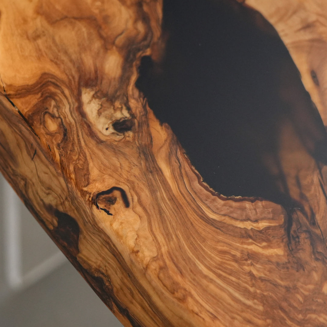 Black epoxy river highlighting organic olive wood contours