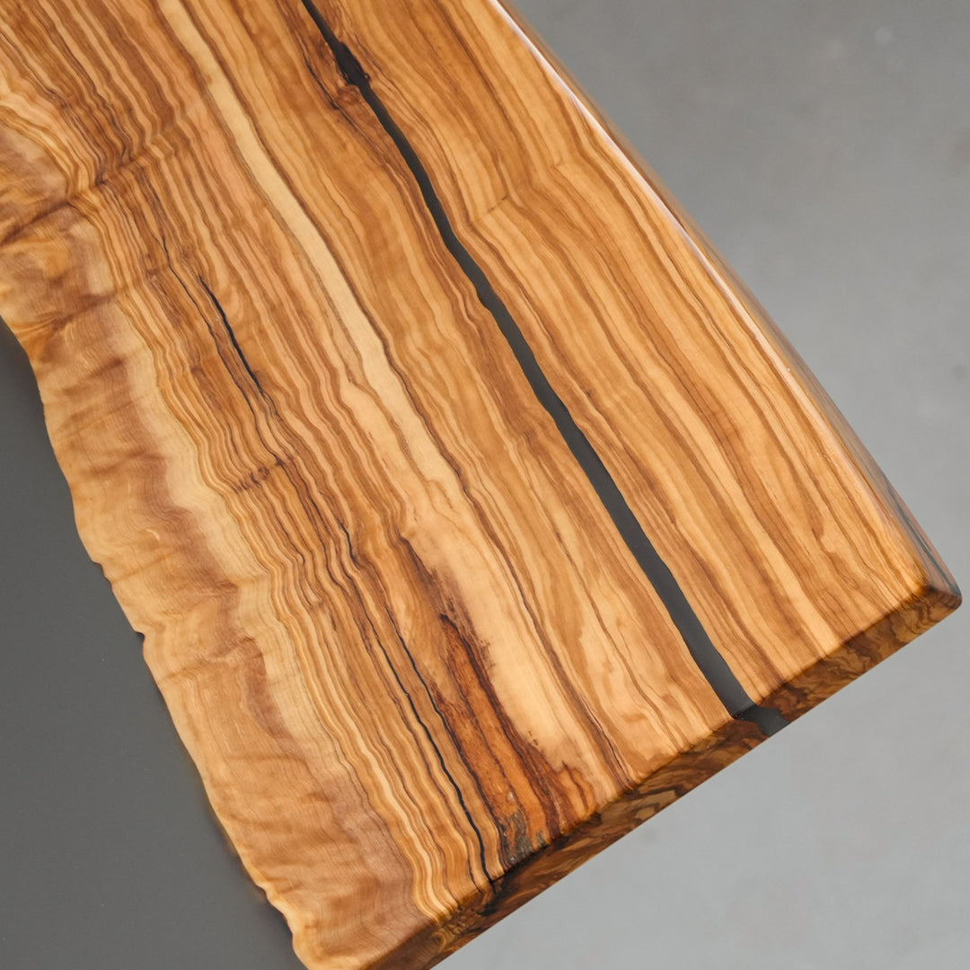 Olive wood slab table showing natural knots and grain movement