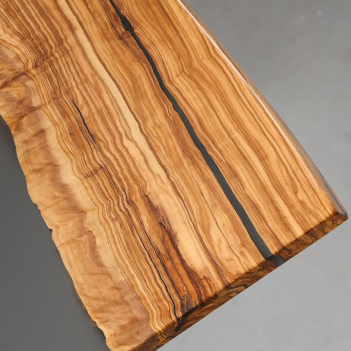 Olive wood slab table showing natural knots and grain movement