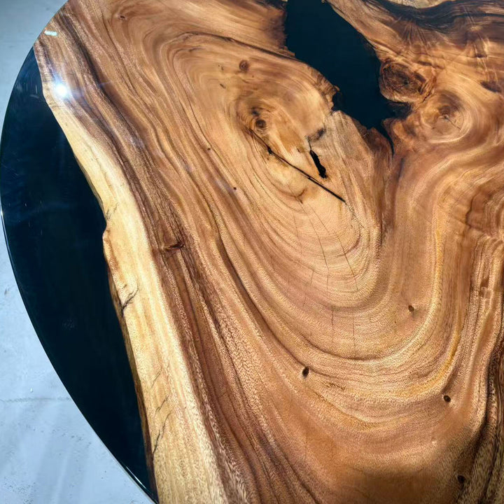 Close detail of swirling olive wood patterns with deep black epoxy