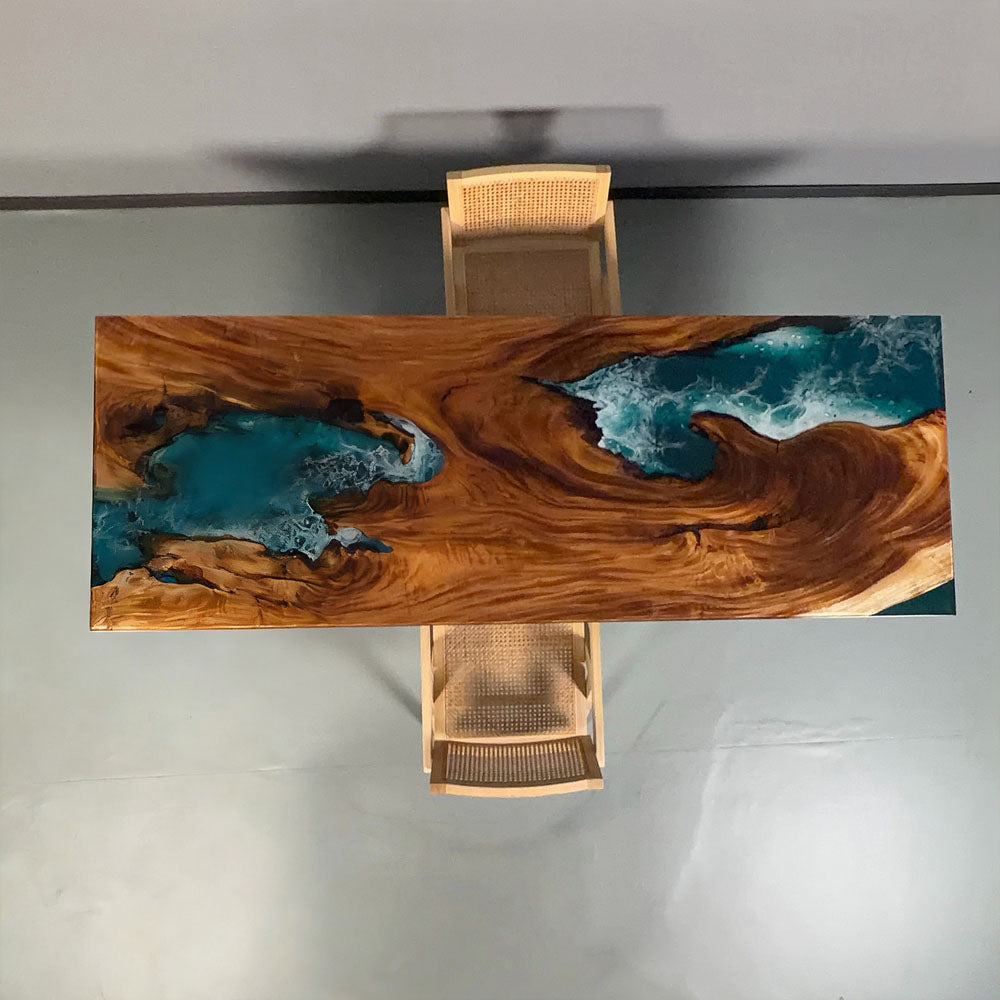 Coastal modern dining room setup featuring the CRT-272 walnut ocean table paired with aesthetic rattan chairs for a luxury Malibu beach house vibe