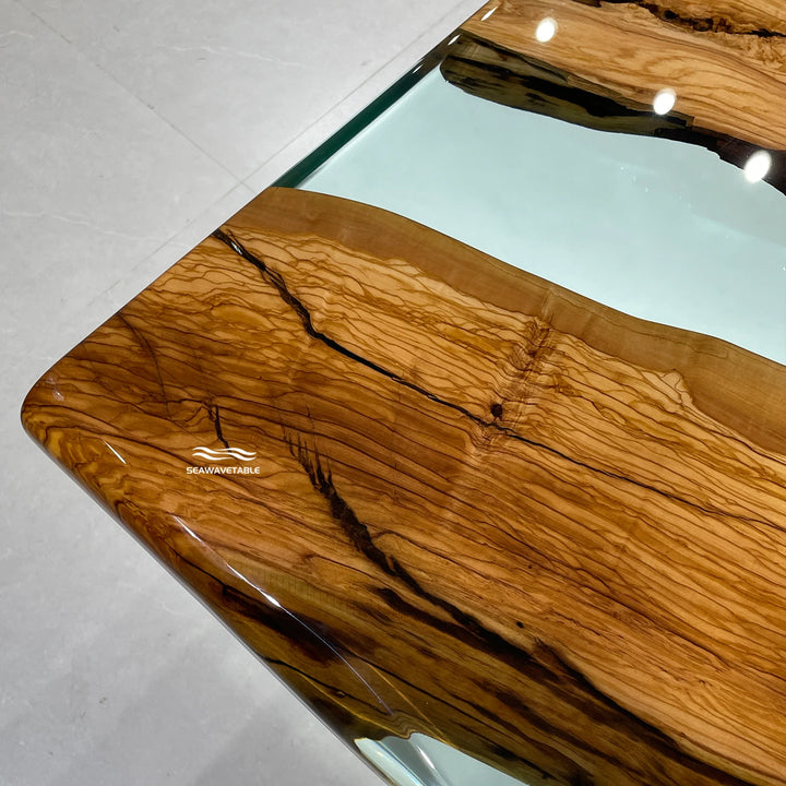 Epoxy Resin Olive Wood Dining Table detail showing flowing blue resin inlay, smooth glossy finish, and artistic epoxy table craftsmanship combined with natural dining table wood materials - SeaWaveTable