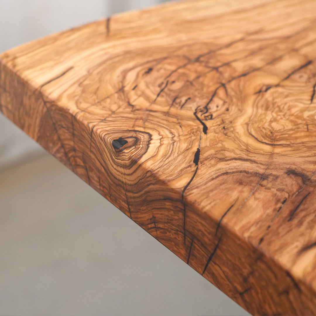 Bespoke honey-toned hardwood table with deep black onyx epoxy river art.