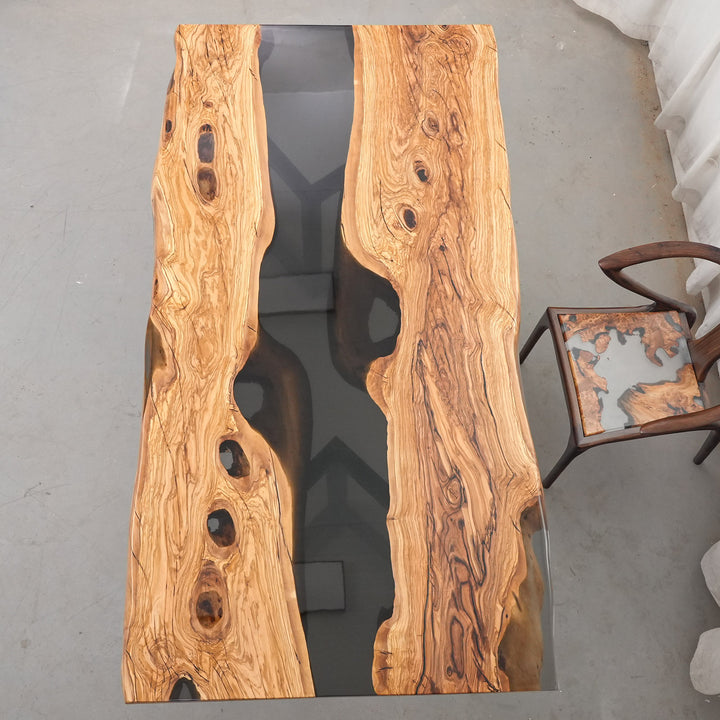 Large live edge wood table with opaque black resin inlay for rustic luxury homes.