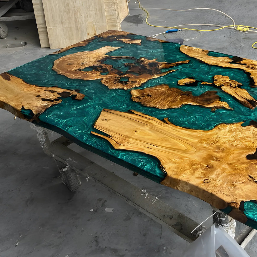 Seawavetable-A large live-edge wooden table showcasing a beautifully polished natural grain surface and flowing teal resin rivers, captured in a professional workshop environment.