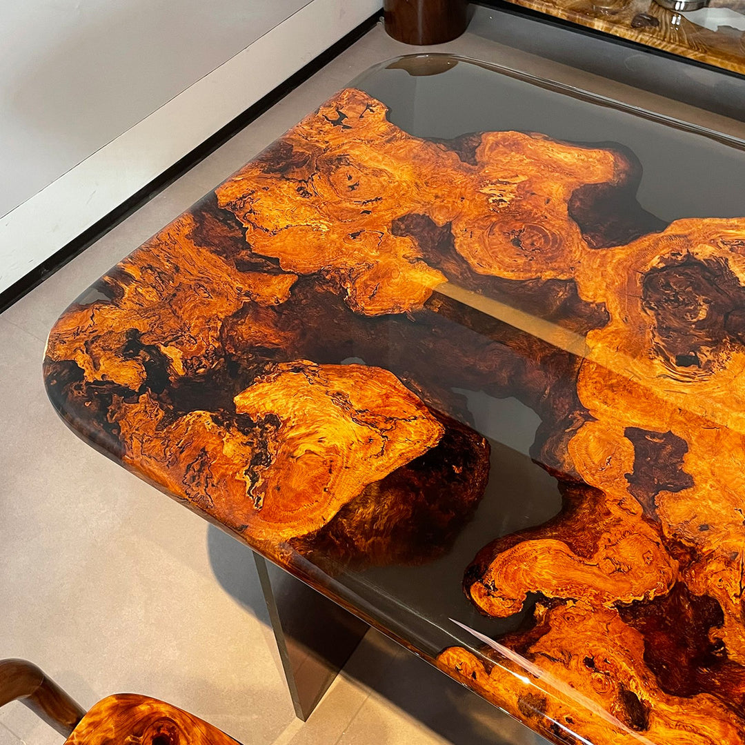 A close - up of a golden camphor wood resin table with intricate natural patterns under a glossy resin surface.