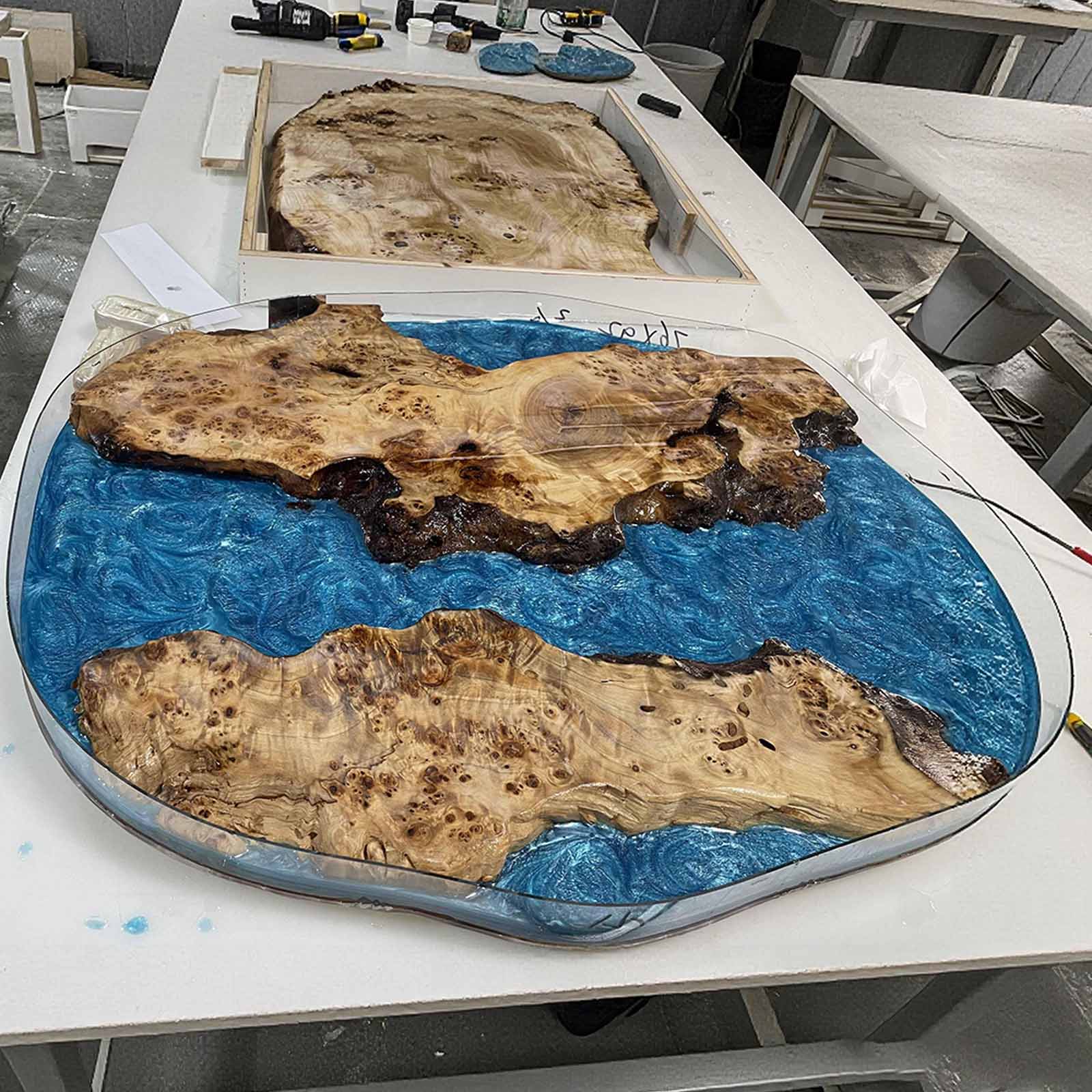Live edge detail of oval coffee table with shimmering blue resin
