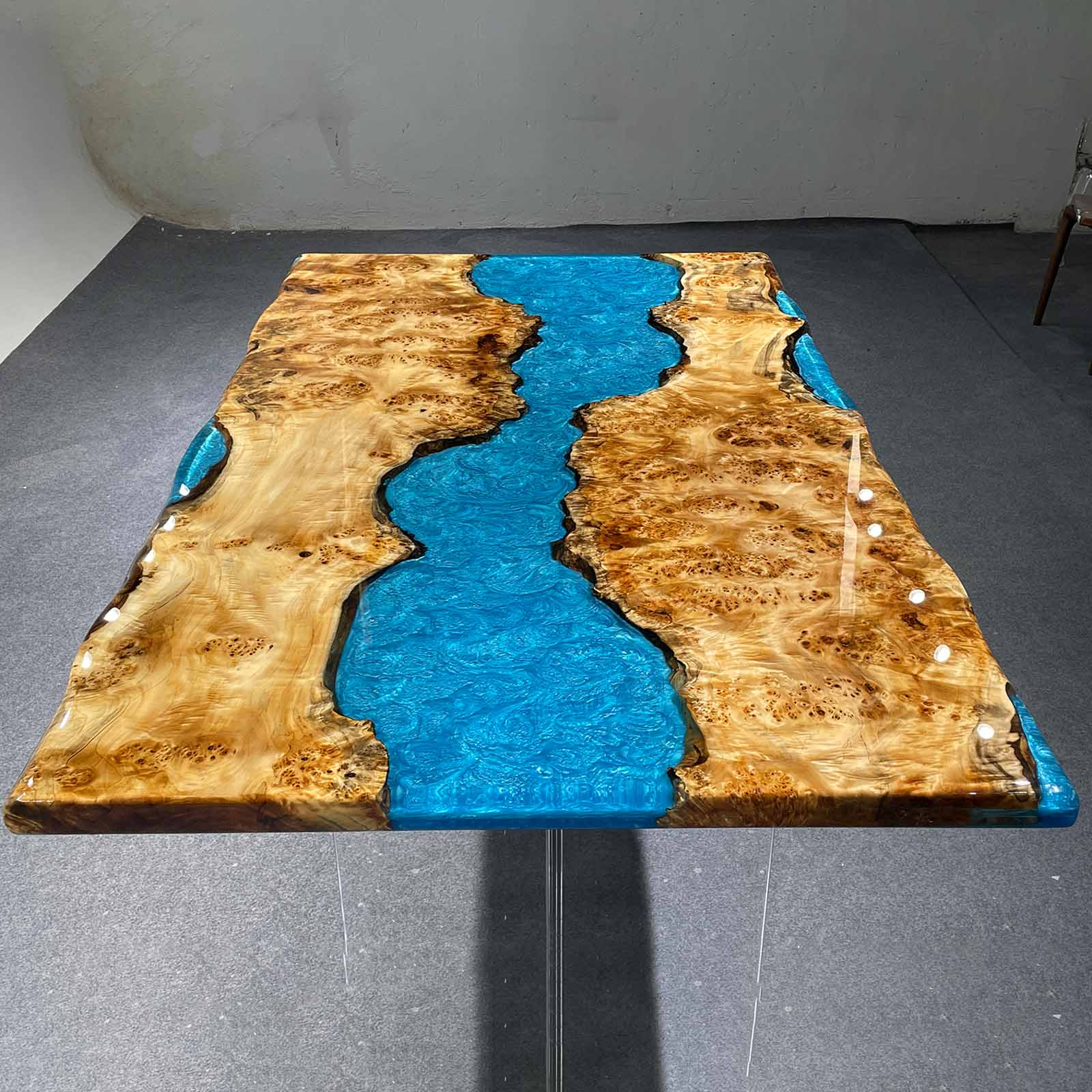 Top view showing wave-like ripples in blue resin, reflecting sunlight