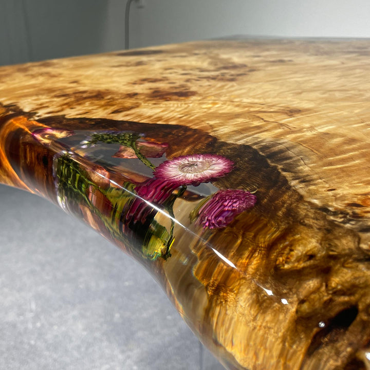 Clear epoxy river table featuring poplar burl and floral accents