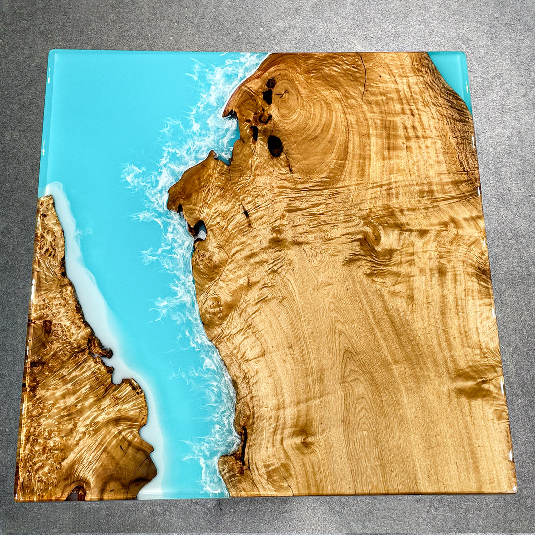 Glossy epoxy resin table with golden camphor slab and ocean-inspired design