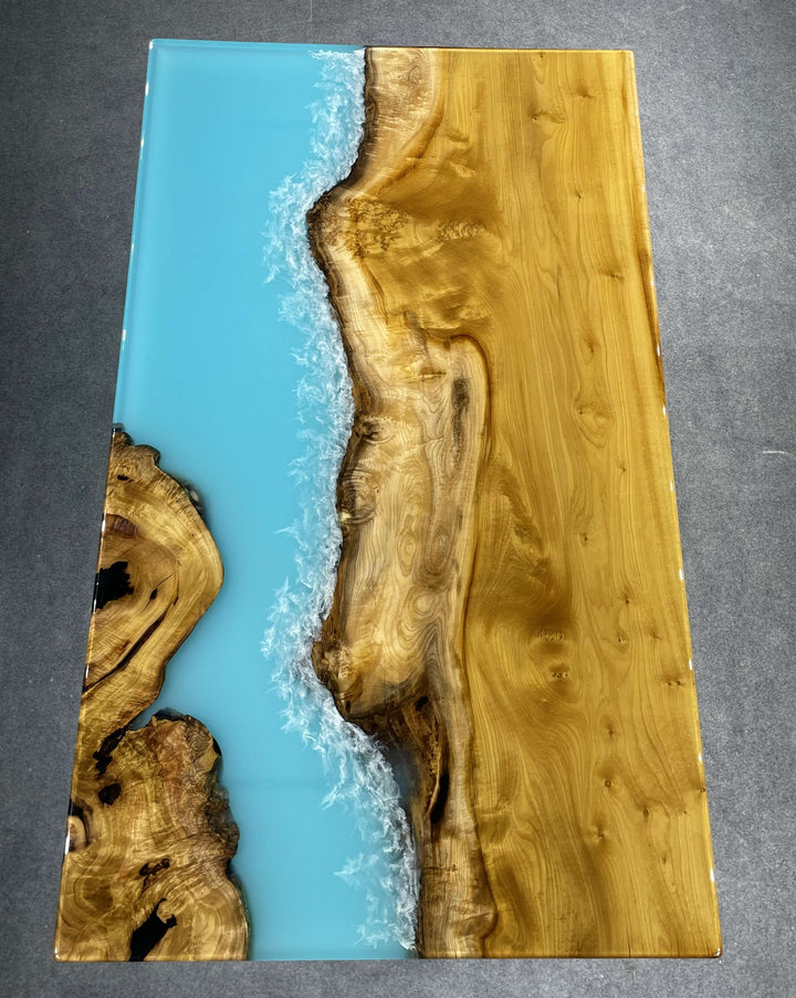 Golden camphor wood resin ocean table with wave design.