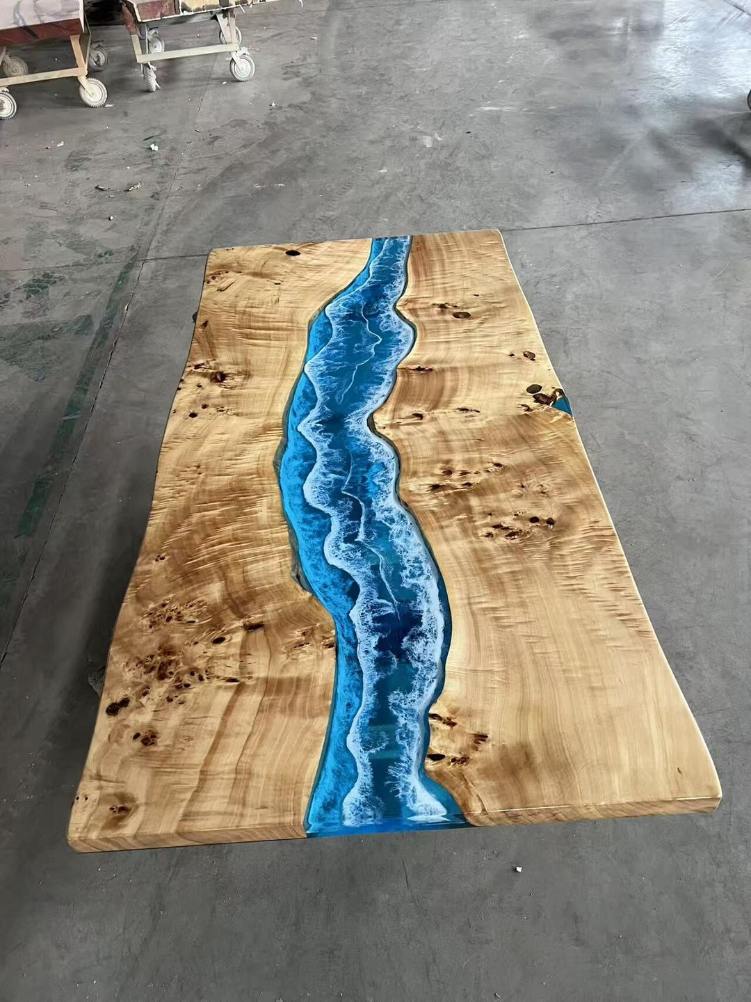 Blue epoxy river table with natural live edge wood slab