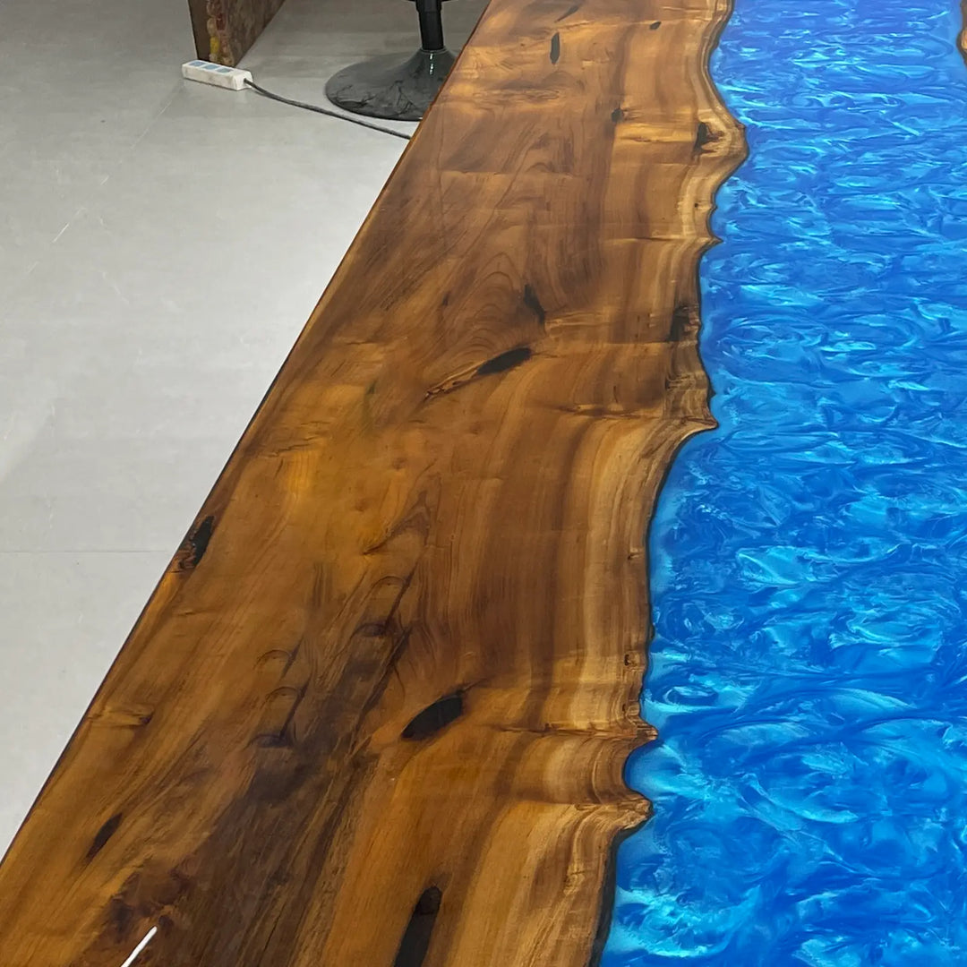 Artistic river resin dining table with contrasting golden wood tones