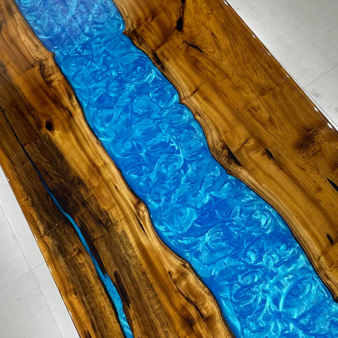 Unique wood slab table with flowing blue resin channels
