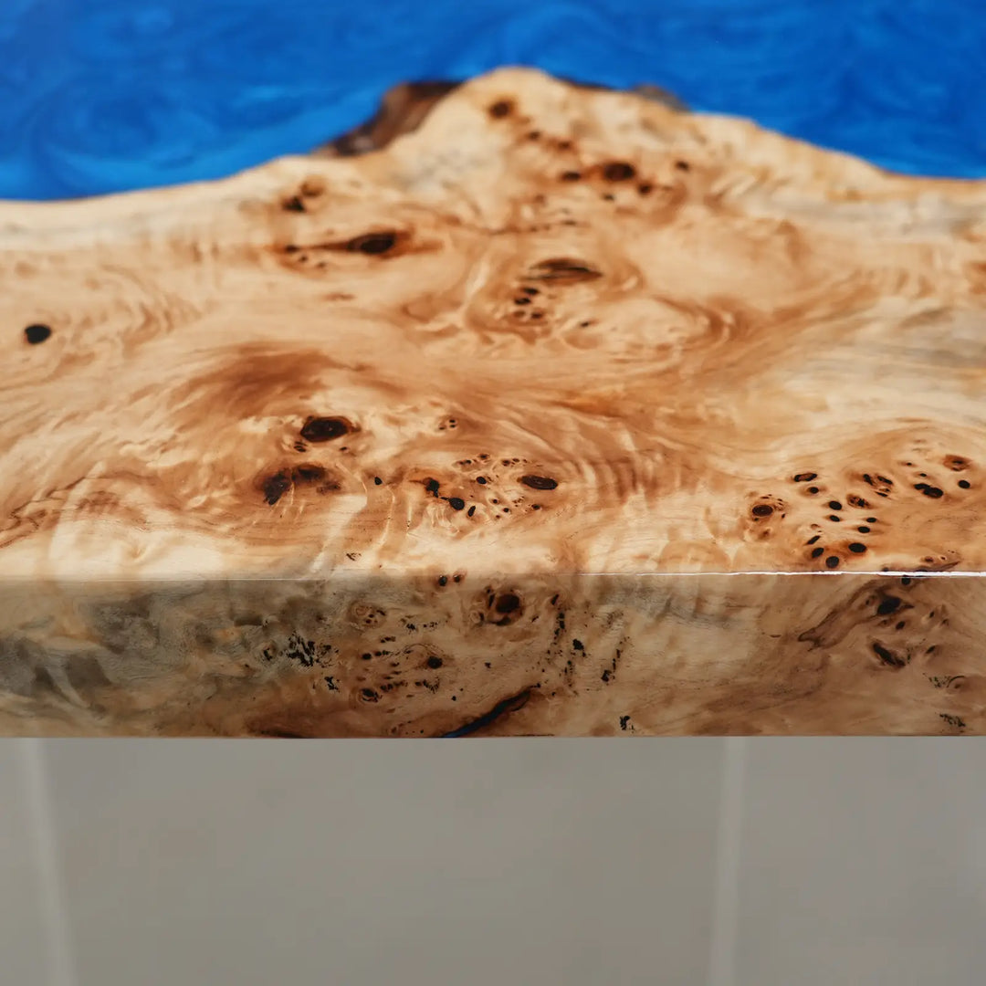Contemporary coastal dining table combining warm wood tones and ocean blue resin