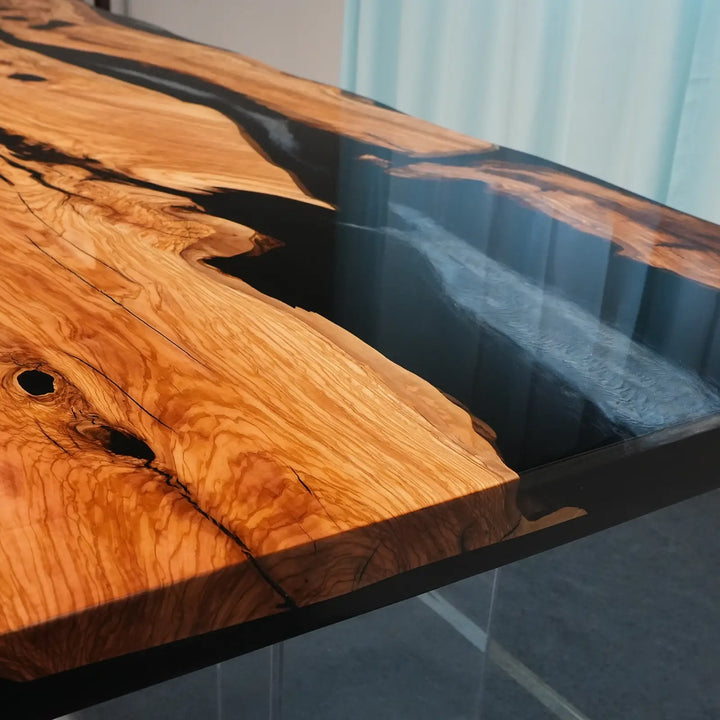 Natural olive wood dining table with organic contours and black resin inlays