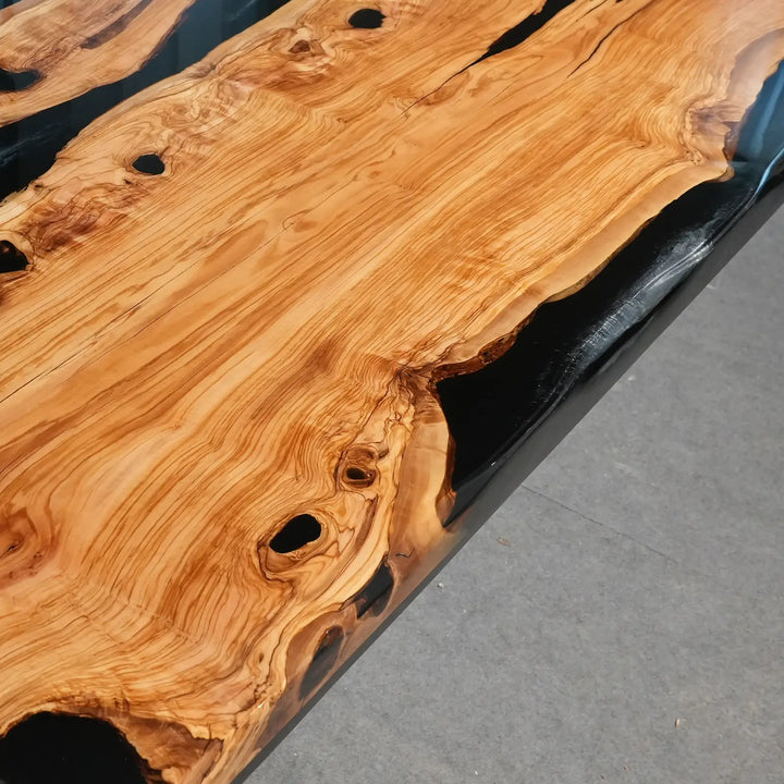 Artisan-crafted olive wood tabletop with deep black epoxy resin rivers
