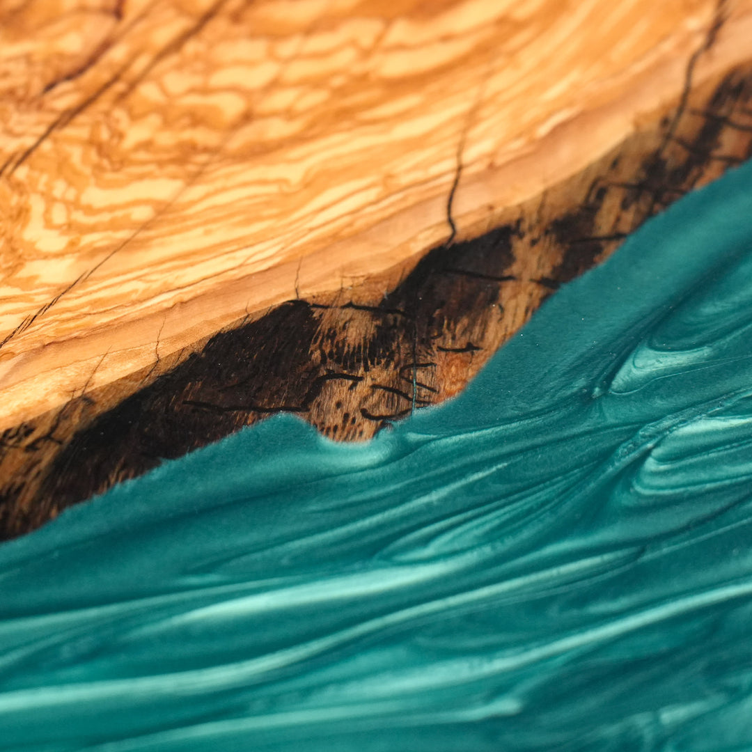 Large luxury live edge table with deep teal pearlescent resin flowing through wood.