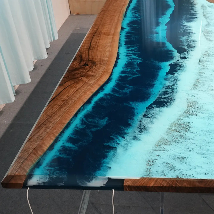 Luxury epoxy river dining table combining rich black walnut grain with vibrant ocean blue resin
