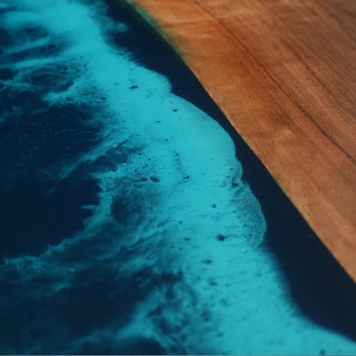 Modern black walnut dining table with turquoise resin waves and illuminated ocean-inspired details
