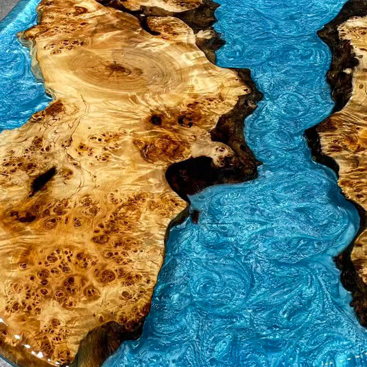 Close-up of poplar wood and azure blue resin swirl design on epoxy river table.
