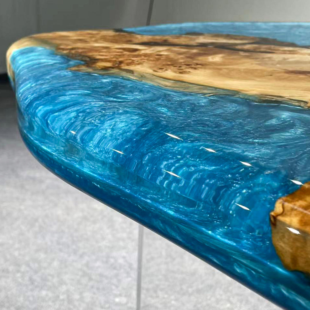 High-gloss poplalr wood table with deep blue resin patterns resembling ocean currents.