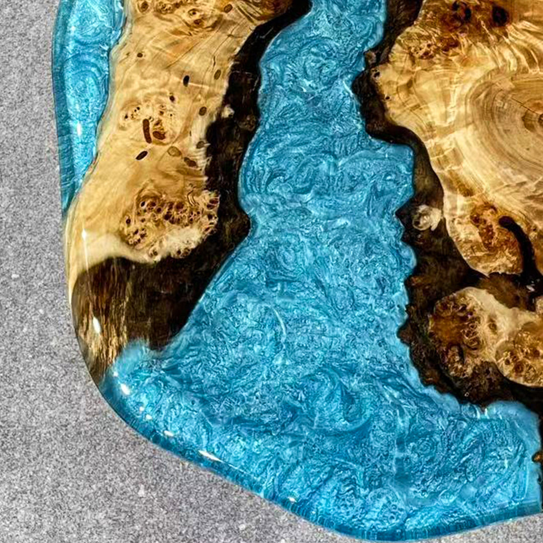 Modern coastal coffee table with blue epoxy river flowing between poplar wood pieces.