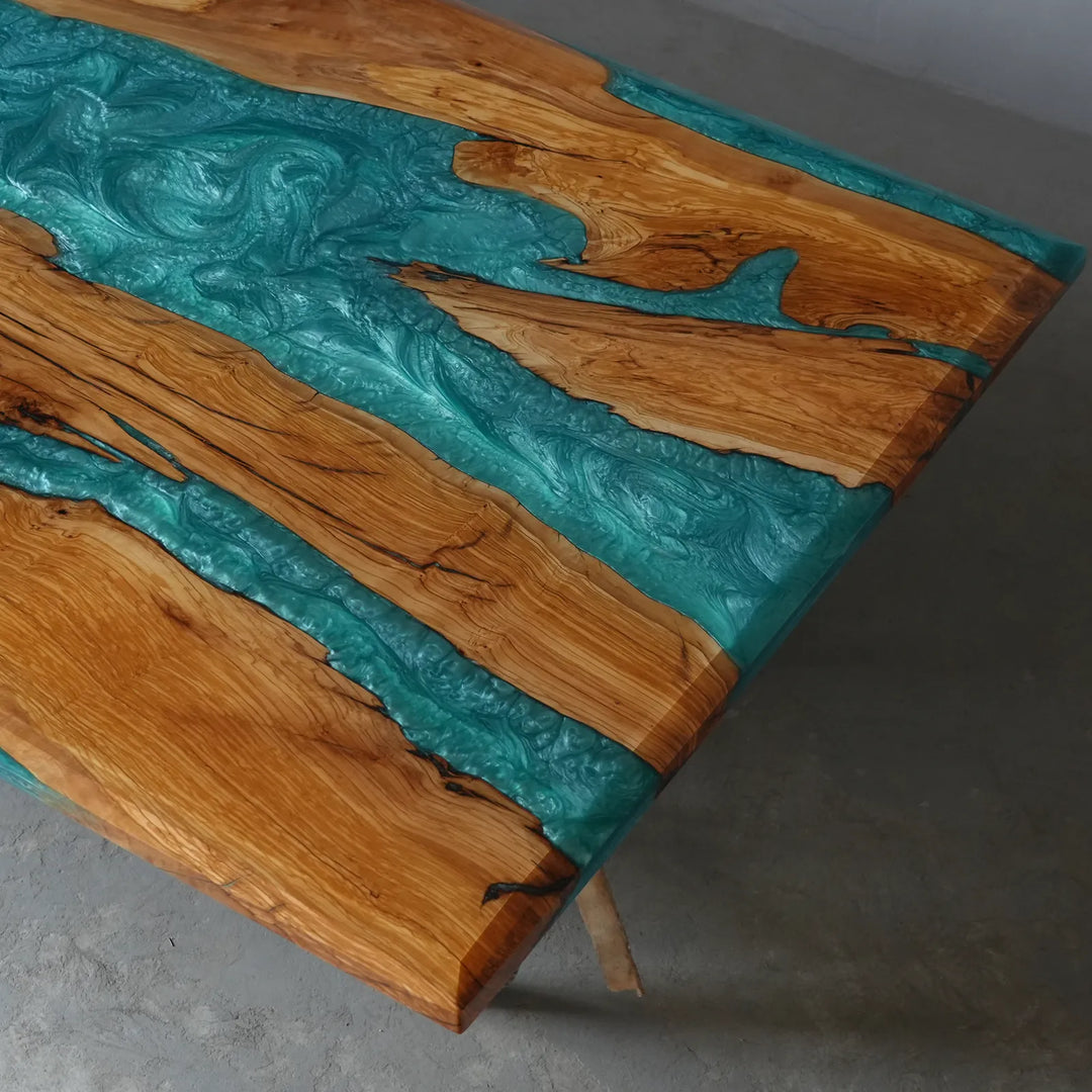 Glossy turquoise resin dining table with warm golden wood grain