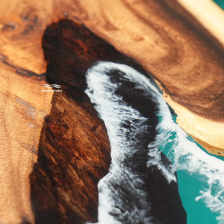 Glossy turquoise resin dining table with white sea foam effects and distinctive wood textures