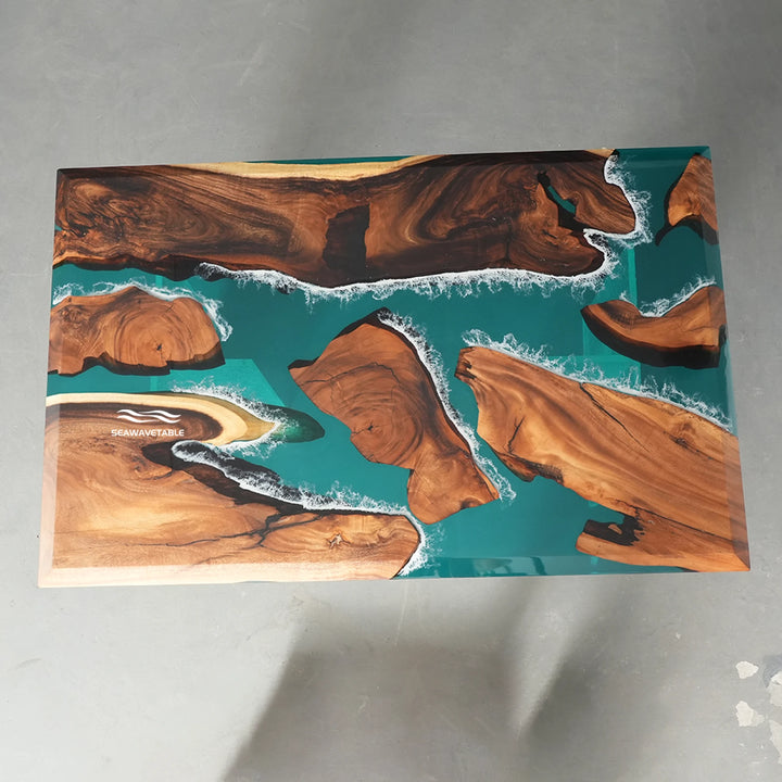 Teal ocean epoxy resin dining table featuring white sea foam details and warm natural wood slabs
